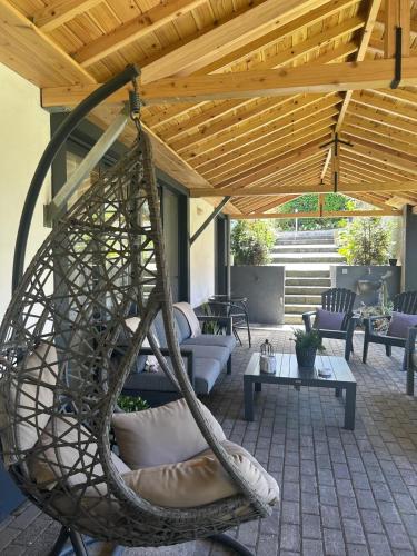 a patio with a swinging chair under a wooden roof at Vila Rosario in Ponta Delgada
