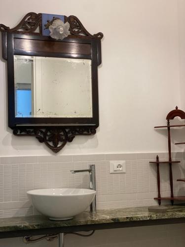 a bathroom with a sink and a mirror on the wall at PHI-Lampara in Santa Flavia