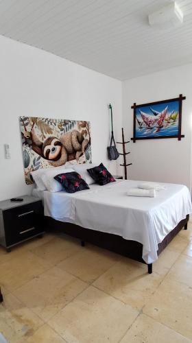 a bedroom with a bed with a stuffed animal on the wall at Pousada Preguiça in Canoa Quebrada