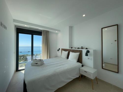 una camera bianca con un grande letto e una grande finestra di Luxury House with Private Pool, Jacuzzi and Wellness Spa a Torrox Costa