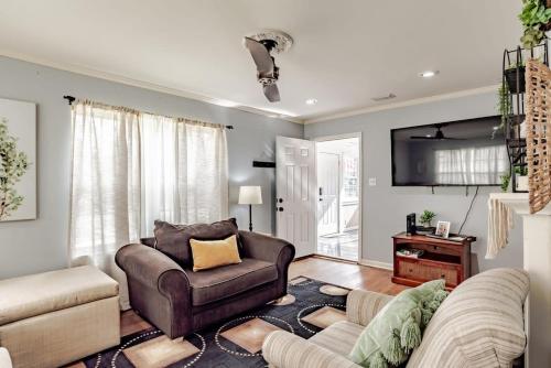 a living room with a couch and a chair at Sunny Midtown Cottage- Midtown Mobile in Mobile