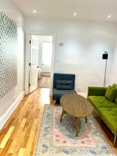 a living room with a green couch and a table at Jersey City Private Entire Apartment - 30 Minutes From Wall St New York City in Jersey City