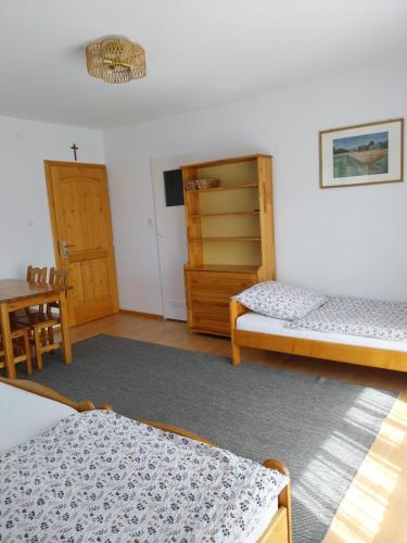 a room with two beds and a table and chairs at Noclegi u Magdy in Sromowce Wyżne