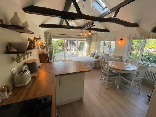 a kitchen and living room with a table and chairs at Lavender Lodge in Briston