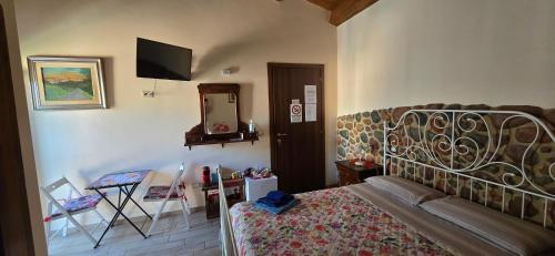 - une chambre avec un lit, un miroir et une télévision dans l'établissement La Dote, à Santo Stefano di Sessanio