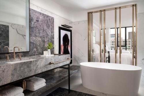 a bathroom with a large tub and a sink at Four Seasons Hotel Montreal in Montréal