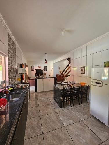 a large kitchen with a table and a white refrigerator at Serradocipó-Casadorey in Serra do Cipo