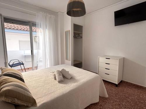 a bedroom with a bed with two towels on it at VMC Rooms in Tavernes de Valldigna