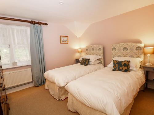 a bedroom with two beds and a window at The Bothy in Macclesfield