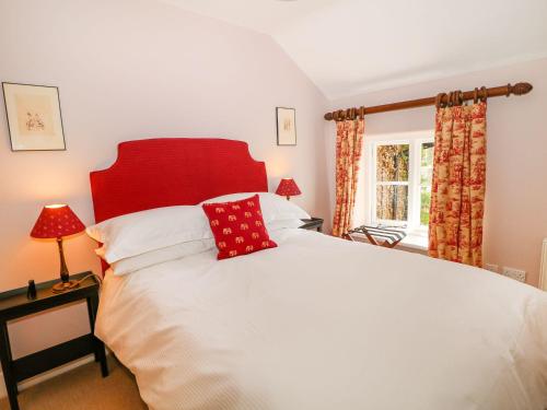 a bedroom with a large white bed with red pillows at The Bothy in Macclesfield