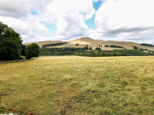 a field of grass with hills in the background at The Bothy in Macclesfield