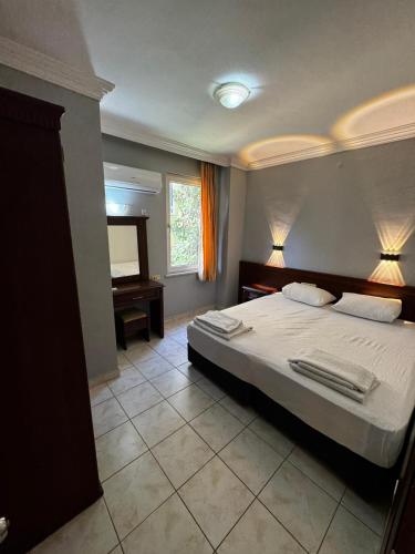 a bedroom with a bed with two towels on it at Rose Garden Apart Hotel in Alanya