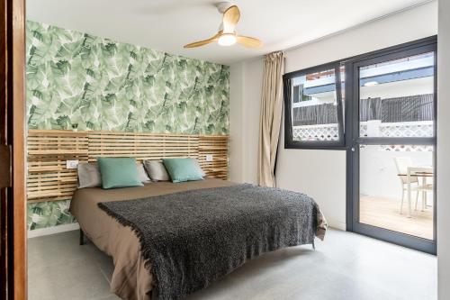 une chambre avec un lit et une porte coulissante en verre dans l'établissement Stylish and central flat - Puerto de la Cruz, à Puerto de la Cruz