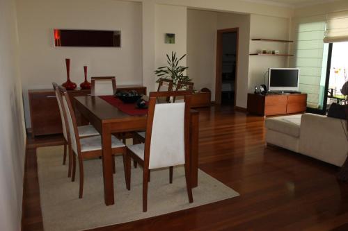 a living room with a dining room table and chairs at Cozy and Bright Apartment in Machico