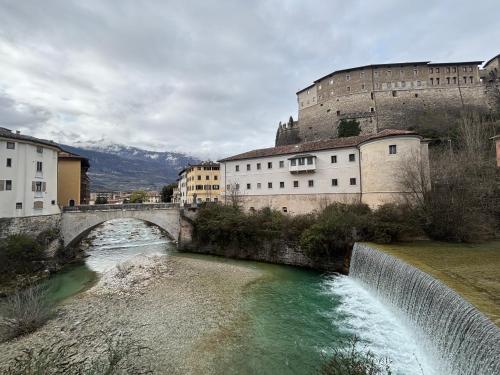 a bridge over a river in front of a castle at Apartments via Roma in Rovereto