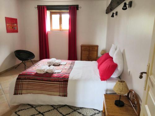 a bedroom with a large bed with red pillows at La Marquise Penchée in Orsennes