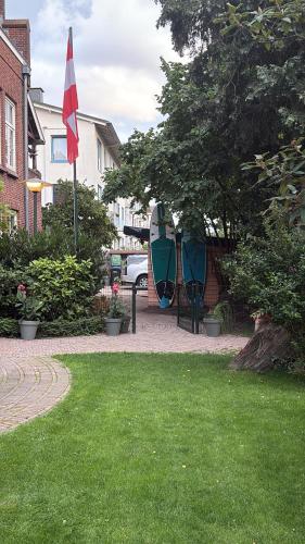 a house with a flag and a table in a yard at Bommelsteijn Lodge in Dordrecht