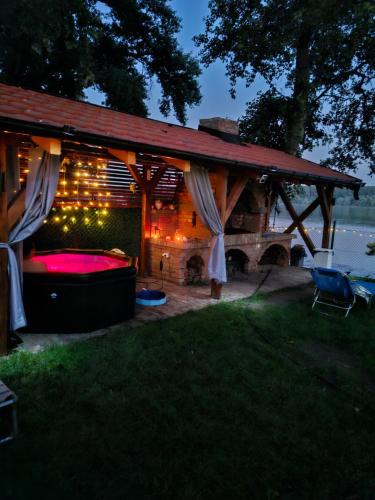 a pergola with a bed in a backyard at night at Vila Marina in Kovin