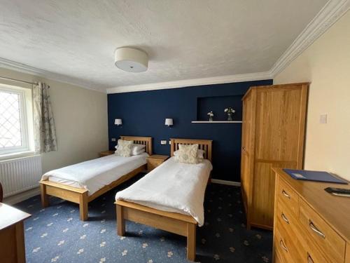 a bedroom with two beds and a blue wall at Springfield Country Hotel, Leisure Club & Spa in Wareham