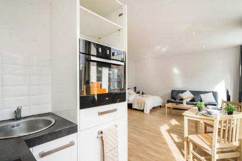 a kitchen and living room with a sink and a table at Spacious Private Studio 89 with parking in Borehamwood