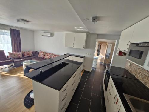 a kitchen with black counter tops and a living room at HOLIDAY NEST Family Guest House 80m2 - Mysigt gästhus med två sovrum i Höör in Höör