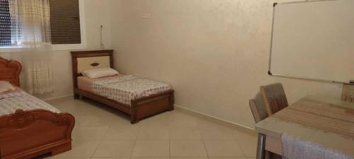 a room with two beds and a chalkboard at Appartement familial Nador Selouane in Selouane