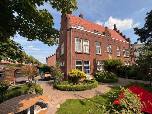 a brick building with a garden in front of it at Bommelsteijn Lodge in Dordrecht
