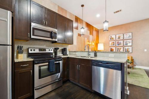 a kitchen with stainless steel appliances and wooden cabinets at Neon Daes Amazing 1 Bedroom Near Vandy and Broadway in Nashville