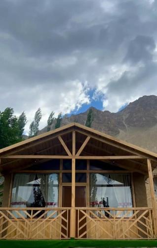 a house with mountains in the background at Trivor Resort Hunza in Hunza