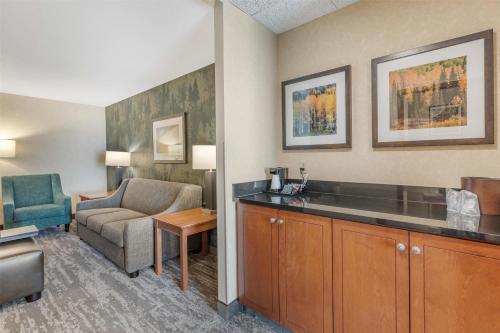 a hotel room with a couch and a chair at Drury Plaza Hotel Denver Central Park in Denver