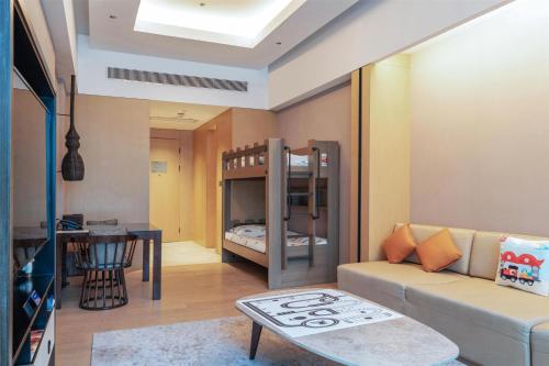 a living room with a couch and a bunk bed at Hilton Shanghai Songjiang Guangfulin in Songjiang