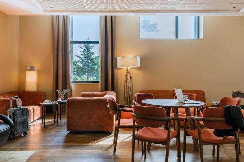 a waiting room with a table and chairs at DoubleTree by Hilton Lyon Eurexpo & Spa in Saint-Priest