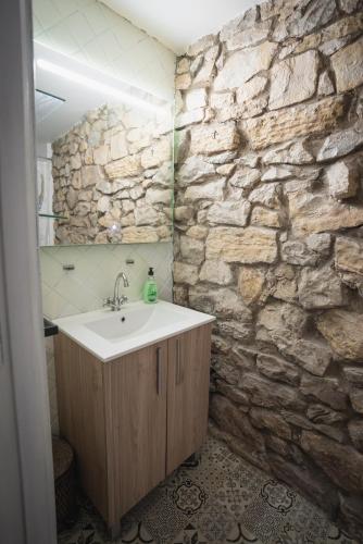 a bathroom with a sink and a stone wall at La Joyuca Del Pas in Mogro