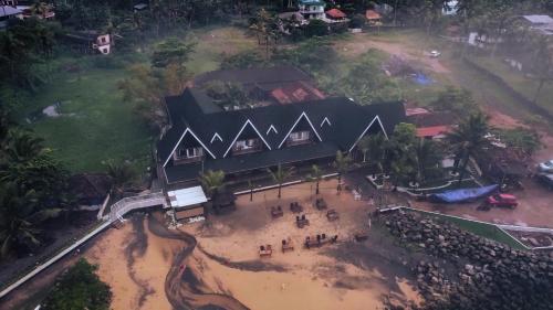an aerial view of a large black building with people in front at Palm TreeHeritage Beach Resort in Varkala