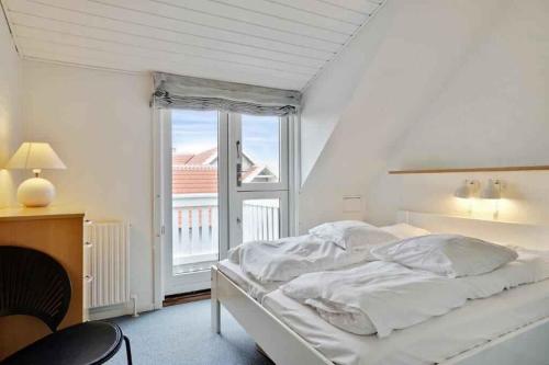 una camera da letto bianca con un letto e una finestra di Unique Holiday Apartment In Old Skagen a Højen