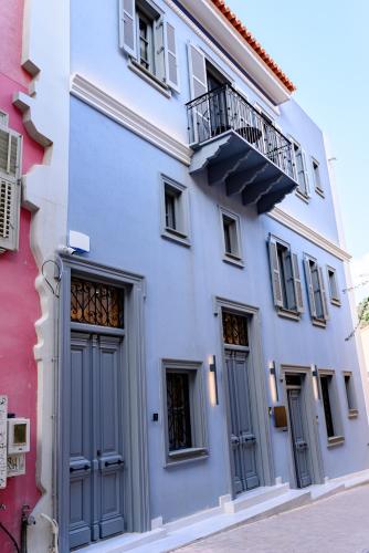 a white building with a balcony on a street at STF Luxury Suites in Nafplio