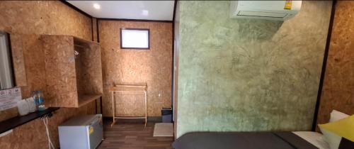 a room with a bed and a wall at TA YAI HOMESTAY (ตา ยาย โฮมสเตย์) in Ko Kood