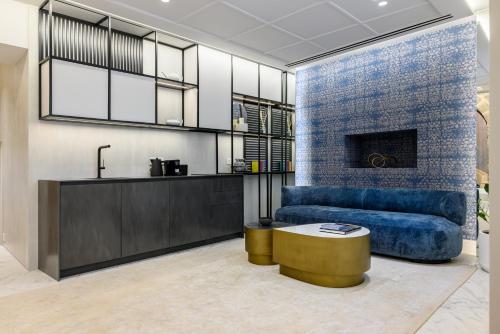 a living room with a blue couch and a table at STF Luxury Suites in Nafplio