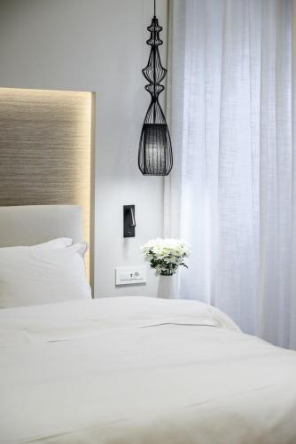 a bedroom with a white bed and a vase of flowers at STF Luxury Suites in Nafplio