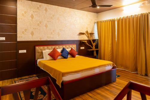 a bedroom with a bed with yellow sheets and pillows at Palm TreeHeritage Beach Resort in Varkala