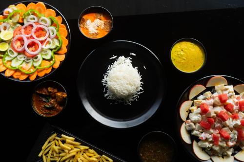 a table topped with plates of food with different foods at Palm TreeHeritage Beach Resort in Varkala