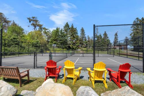 a group of colorful chairs and a tennis court at White Point Beach Resort in Summerville Centre