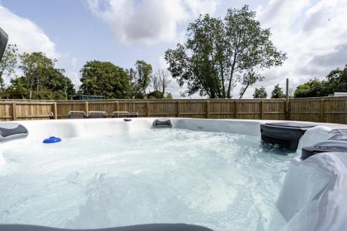 a hot tub in a backyard with a wooden fence at Devon Hot Tub Retreat in Bideford