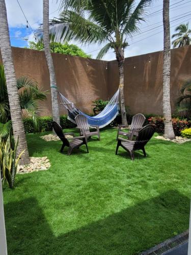 two chairs and a hammock in a yard with palm trees at Lakefront Paradise Retreat, Private Pool Vacation Home in Rivas, between Ometepe, Tola and San Juan del Sur in San Jorge