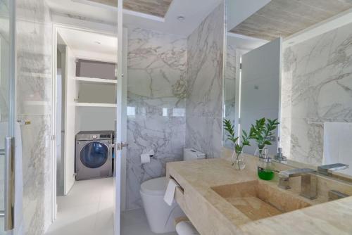 a bathroom with a sink and a washing machine at Aquarella Caribbean Paradise Playa Juan Dolio in La Puntica de Juan Dolio