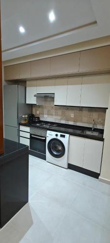 a kitchen with a stove and a washing machine at Luxury Mirador 3 Cappuccino in Cabo Negro