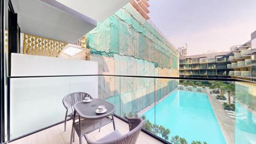 a balcony with a table and a swimming pool at Vacationer Holiday Homes I Stylish 2 Bed l Balcony with Pool Views l JVC in Dubai