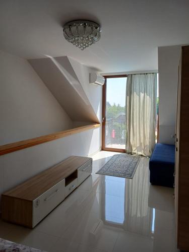 a living room with a couch and a window at Sunčani Breg Apartments Vrdnik in Vrdnik