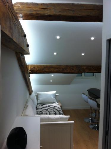 une chambre avec un lit dans une pièce avec des plafonds en bois dans l'établissement Studio Haut de Gamme - Centre Ville, à Cannes