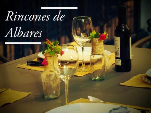 a table with two glasses and a bottle of wine at Casa Rural Rincones de Albares in Albares